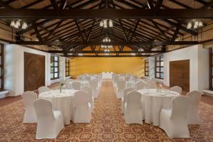 a banquet hall with white tables and white chairs at The Fern Samali Resort Dapoli, Series by Marriott in Dapoli +14 photos