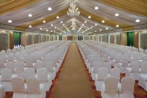 un pasillo vacío con sillas blancas y una lámpara de araña en The Fern Sardar Sarovar Resort Kevadia, Gujarat, Series by Marriott, en Kevadia 69 fotos más