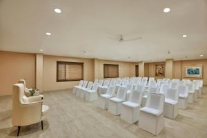 a room with rows of white chairs and tables at The Fern Residency, Bodhgaya, Series by Marriott in Bodh Gaya