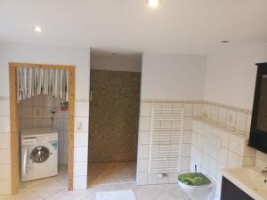 Großes Haus bei Rostock Lüsewitzer Krug bis 10 Personen في Klein Lüsewitz: حمام مع غسالة ملابس وغسالة ملابس