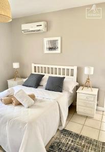 Villa Le Coin - T2 moderne climatisé avec Wi-Fi في Midlands Station: سريرين بملاءات بيضاء في غرفة النوم