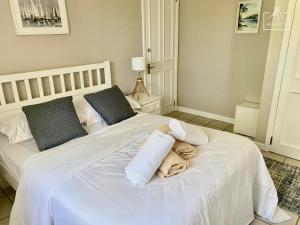 Villa Le Coin - T2 moderne climatisé avec Wi-Fi في Midlands Station: سرير أبيض مع مناشف فوقه