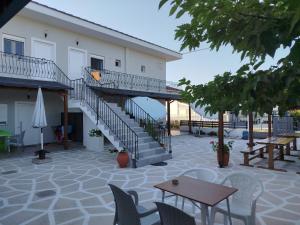 a patio with a staircase and tables and chairs at Harmony Apartments in Larisa