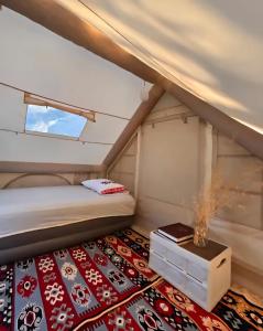 a bed in a small room with a rug at Cimarte The Path Lukove in Lukovë