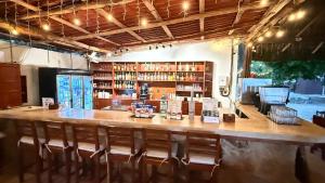 a restaurant with a large wooden bar with chairs at Hotel Fisherman lodge, cuarto base triple in Punta Allen