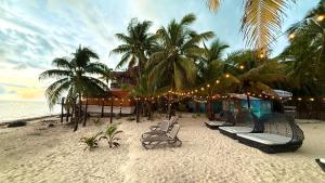 a beach with chairs and palm trees and lights at Hotel Fisherman lodge, cuarto base triple in Punta Allen +13 photos
