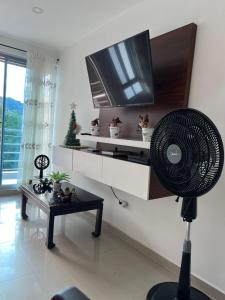 a living room with a fan and a tv at Apartamento exclusivo con Piscina y Vista panoramica, Anapoima Centro in Anapoima