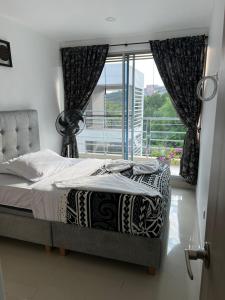 Un dormitorio con una cama y una ventana grande. en Apartamento con Piscina y Vista panoramica Anapoima Centro, en Anapoima 17 fotos más