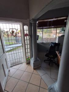 an open door to a room with a desk and a chair at M J GuestHouse in Boksburg