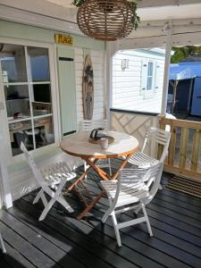 een tafel en stoelen op de veranda van een huis bij Julieregis in Biscarrosse