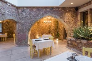 a dining room with a table and a stone wall at Spilia Village Hotel & Villas in Spiliá