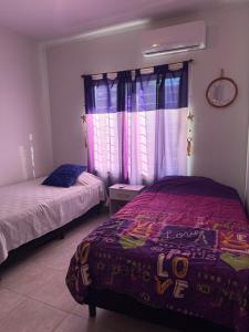 波萨达斯Casa Yvy Guazú的一间卧室，配有两张床和一扇窗户