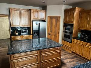 a kitchen with wooden cabinets and a granite counter top at Torreon Getaway on the Greens with hot tub, 4 bedrooms, sleeps 10 in Show Low +20 photos