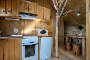 una cocina con fogones y un árbol. en Domaine de Dienné - Villages Vacances, en Dienné
