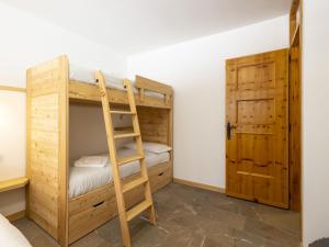 ein Schlafzimmer mit Etagenbetten, einer Leiter und einer Tür in der Unterkunft Apartment -1 by Interhome in Madesimo