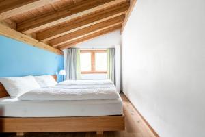 un lit dans une chambre avec un plafond en bois dans l'établissement Ari Resort Apartments, à Zermatt