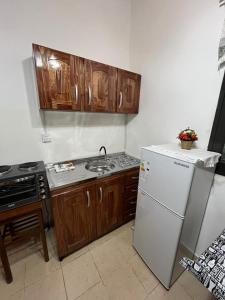 une cuisine avec des armoires en bois et un réfrigérateur blanc dans l'établissement Monoambiente zona Centrico, à Posadas