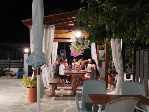 a group of people sitting at a table under an umbrella at Harmony Apartments in Larisa