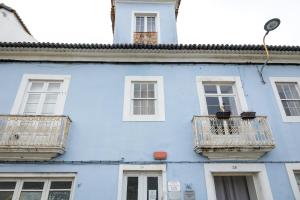 un edificio blu con finestre bianche e balconi di Afternoon Desire a Ponta Delgada
