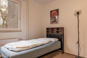 MK Apartments Delmenhorst nähe Bremen 1 في دلمنهورست: غرفة نوم بها سرير ونافذة +صورتان