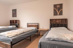 MK Apartments Delmenhorst nähe Bremen 1 في دلمنهورست: غرفة بثلاث اسرة وطاولتين