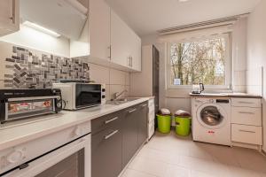 MK Apartments Delmenhorst nähe Bremen 1 في دلمنهورست: مطبخ مع غسالة ملابس وميكروويف