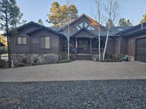 a wooden house with a driveway in front of it at Torreon Getaway on the Greens with hot tub, 4 bedrooms, sleeps 10 in Show Low