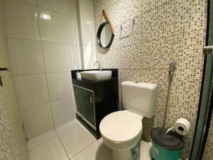 a bathroom with a white toilet and a sink at Apartamento á 5 minutos do centro in Garanhuns +15 photos
