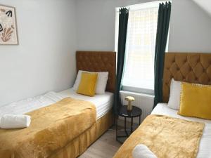 Un dormitorio con dos camas y una ventana. en Elegant Retreat 6 Mins Drive from Ferry With Free Parking, en Dover