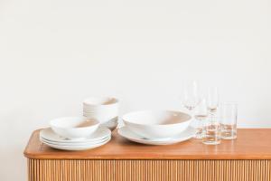 einen Tisch mit Schalen, Teller und Gläsern darauf in der Unterkunft Ari Resort Apartments in Zermatt