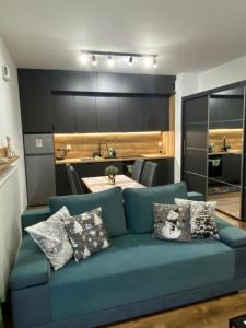 un soggiorno con divano blu e cuscini di EM Room a Cracovia