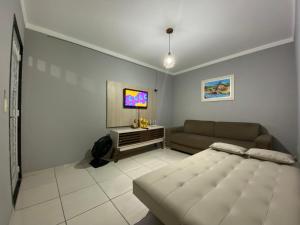 a living room with a bed and a couch at Apartamento á 5 minutos do centro in Garanhuns