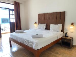 a bedroom with a large bed with two pillows on it at Hotel Sky Blue Baga Goa in Baga