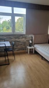 a bedroom with a bed and a desk and two windows at RELAX Privacy in Sarcelles