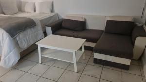 a room with a bed and a couch and a table at RELAX Privacy in Sarcelles +2 photos