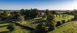 an aerial view of a house in a field with trees at Comarca LAS LIEBRES HOTEL RESTAURANT & VIÑEDO in Colonia del Sacramento
