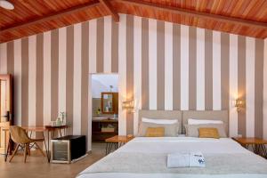 a bedroom with a bed and a desk and a television at Blu Galapagos Sustainable Waterfront Lodge in Puerto Ayora