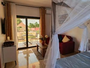 Les Studios de l'Oasis في Ngaparou: غرفة نوم بسرير ومنظر على فناء