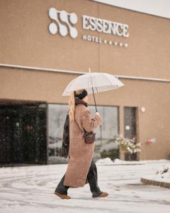 a woman walking in the snow with an umbrella at Hotel Essence in Pogány