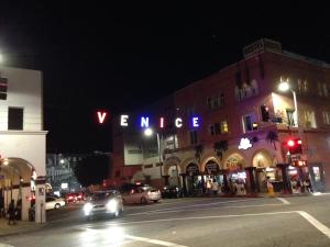 a city street at night with a large building at Venice Beach Hostel in Los Angeles