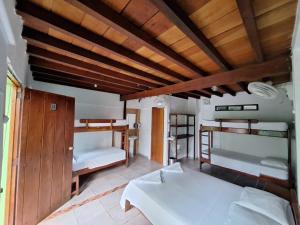 Hostal Capurgana في كابورغانا: غرفة بسريرين وسقف خشبي