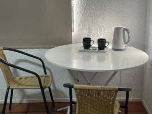 Habitación doble superior en el centro, con baño في كوريكو: طاولة بيضاء مع كوبين وكرسيين