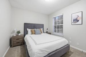 a white bedroom with a large bed and a window at Trendy 2BR2BA Highland Park Escape in Clarksville
