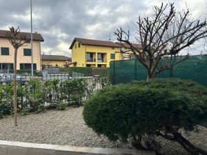 un edificio con una valla y un árbol en un patio en Casa del Melograno Outlet, en Serravalle Scrivia