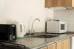 a kitchen counter with a sink and a microwave at Grin Apartments in San Rafael