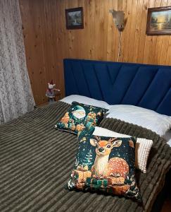 a bed with two pillows with a deer on it at Cottage u Romana in Yaremche