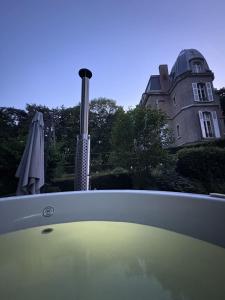 a bath tub with a building in the background at Domaine des Monts de la Baie in Mareuil-Caubert