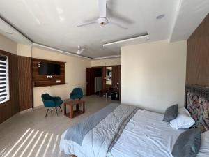 ein Schlafzimmer mit einem Bett, einem Tisch und Stühlen in der Unterkunft Keshav Hotel Haridwar in Haridwar