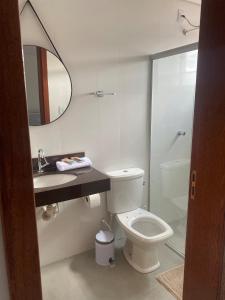 ein Badezimmer mit Toilette, Waschbecken und Spiegel in der Unterkunft Apartamento em Mariana in Mariana
