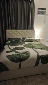 un letto con una coperta verde e bianca sopra di Edades Farms a Taysan